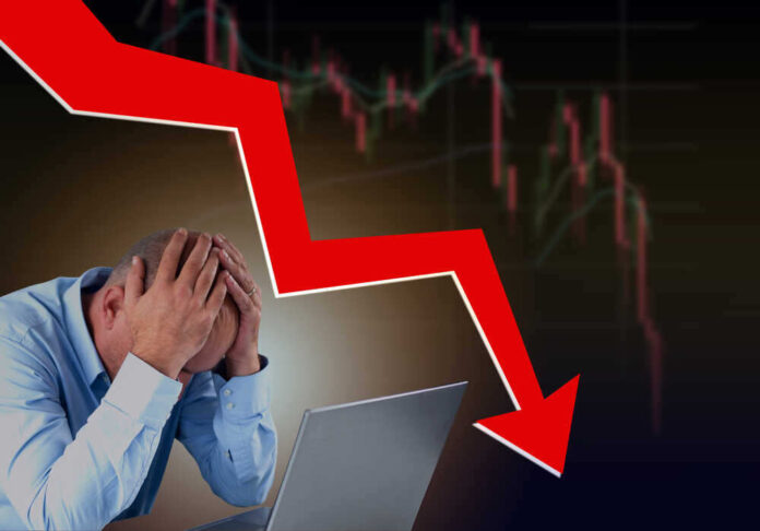 shutterstock_2009223203.jpg featured image Man stressed over falling stock market graph.
