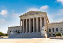 U.S. Supreme Court building exterior under blue sky.