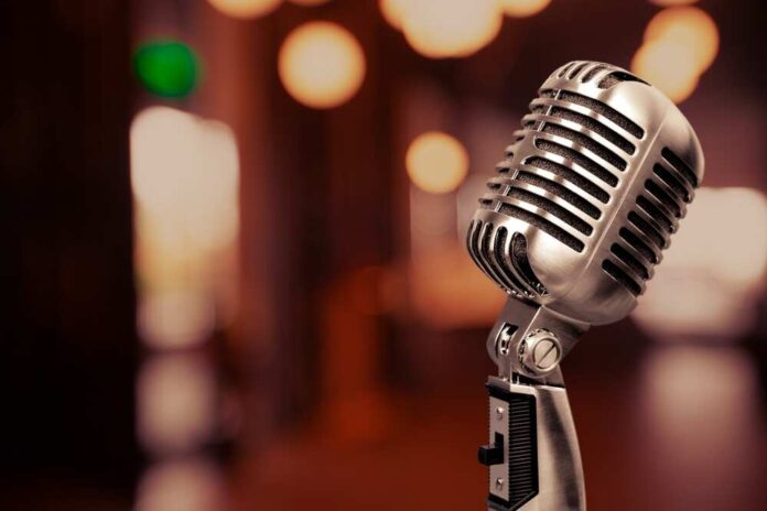 shutterstock_2337165521.jpg featured image Retro microphone with blurred background lights.