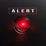 Red alert light on black background