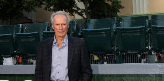Man in suit standing in front of green seats