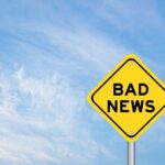 Yellow sign reads bad news in sky