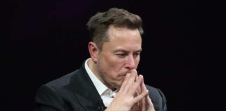 Elon Musk in suit thinking.