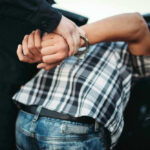 Person in handcuffs arrested by police officer