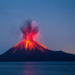 Volcano erupting with bright lava and smoke display