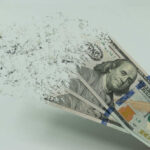 Hundred dollar bills disintegrating in hand