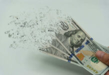 Hundred dollar bills disintegrating in hand