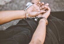 Person in handcuffs with hands behind back.