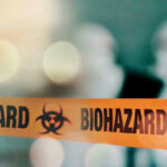 Biohazard tape with blurred figures in background