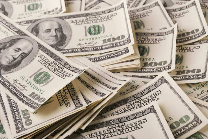Stacks of one hundred dollar bills scattered