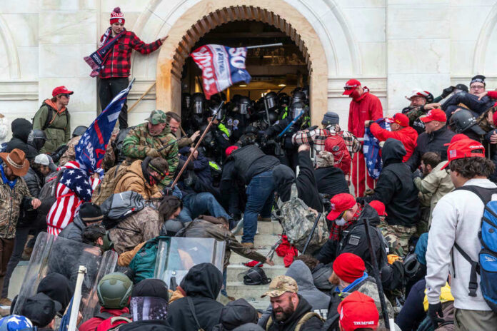 Crowd storming entrance of a government building with flags