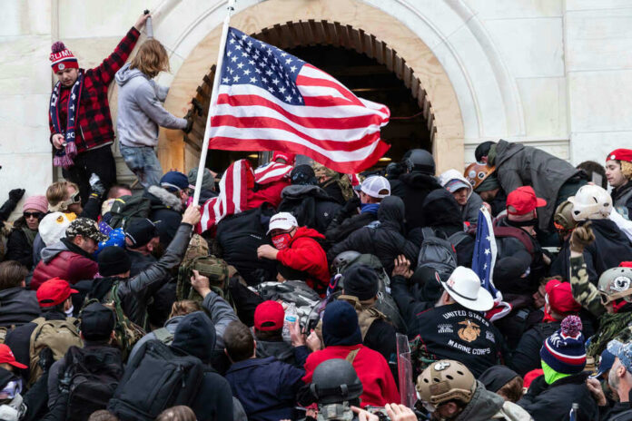 Crowd storming a building, waving an American flag