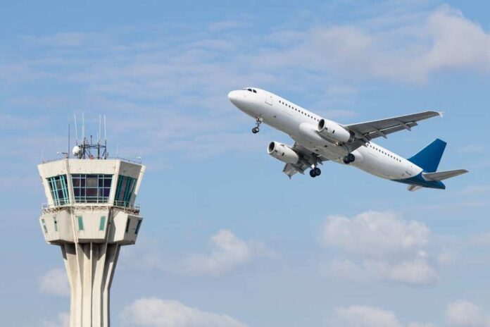 An airplane taking off near an airport control tower
