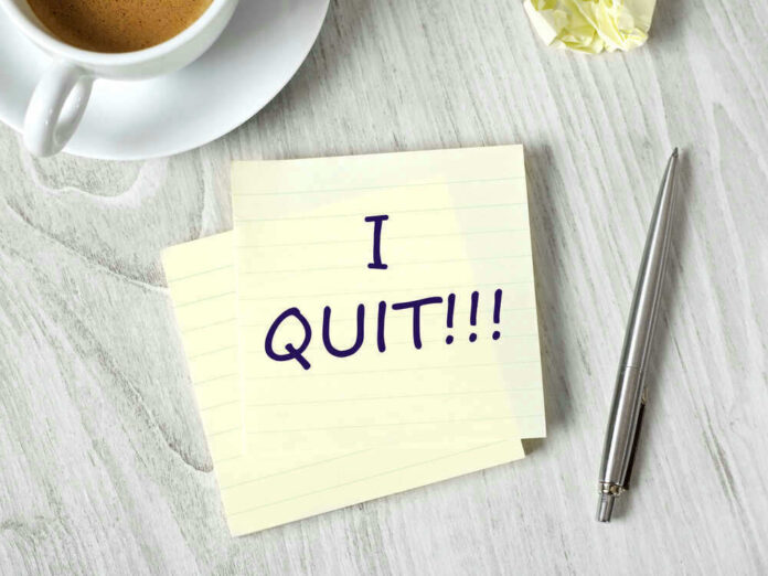 Note with I QUIT near coffee, pen, paper ball.