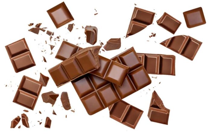 Pieces of chocolate bars scattered on a white background