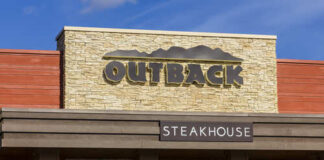 Exterior view of an Outback Steakhouse restaurant with a stone facade