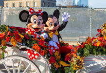 Mickey and Minnie Mouse waving from decorated carriage.