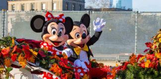 Mickey and Minnie Mouse waving from decorated carriage.