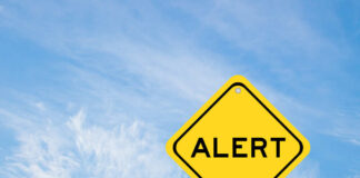Yellow alert sign against a blue sky