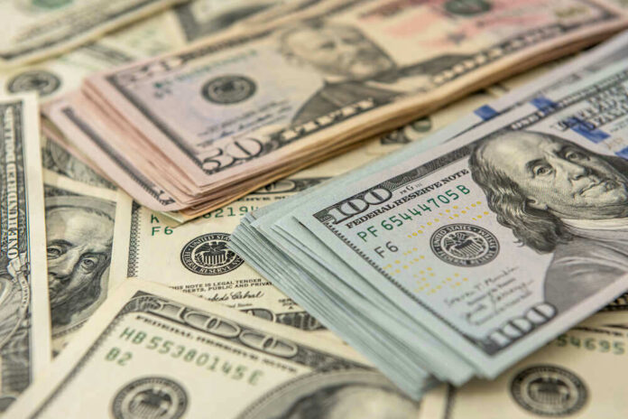 Stacks of US dollars featuring Benjamin Franklin and Ulysses S. Grant.