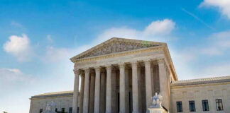 U.S. Supreme Court building exterior under blue sky.