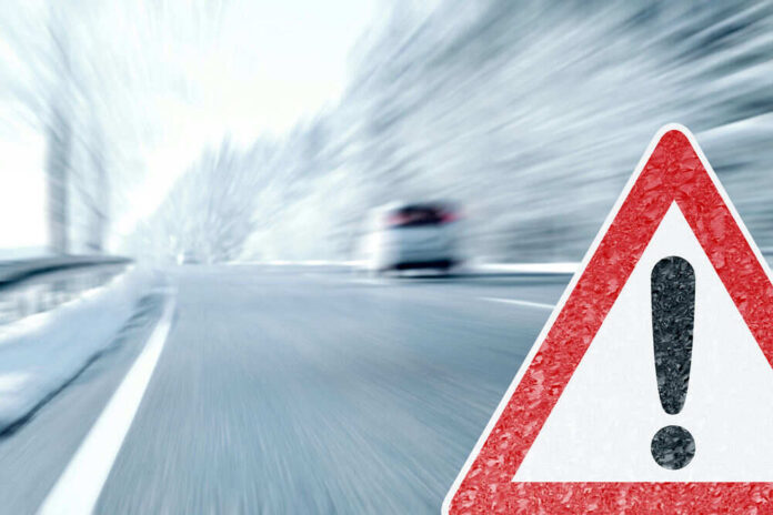 Road sign warning blurred highway scene
