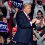Person clapping at a political rally event.