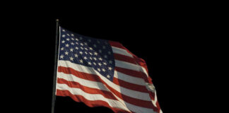American flag waving against a black background.