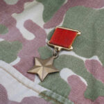 A military medal displayed on camouflage fabric