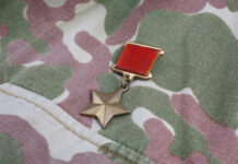 A military medal displayed on camouflage fabric