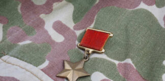 A military medal displayed on camouflage fabric