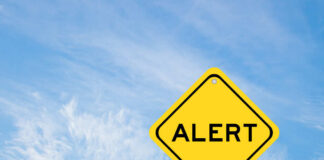 Yellow alert sign against a blue sky