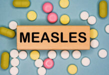 QUARANTINE Crisis: Measles Erupts Wooden block with the word 'MEASLES' surrounded by various pills