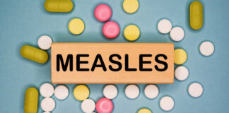Wooden block with the word 'MEASLES' surrounded by various pills