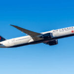 Air Canada airplane flying against a clear blue sky