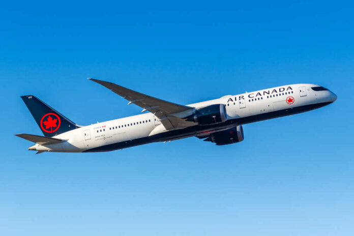 Air Canada airplane flying against a clear blue sky