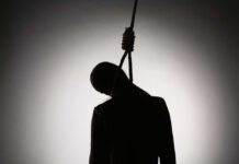 Silhouette of a person hanging with a rope in a dark background