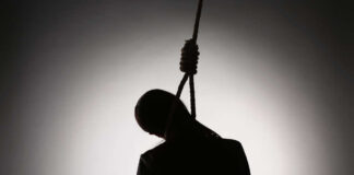 Silhouette of a person hanging with a rope in a dark background