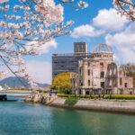 View of the Hiroshima Peace Memorial with cherry blossoms in the foreground