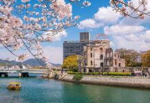 View of the Hiroshima Peace Memorial with cherry blossoms in the foreground