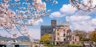View of the Hiroshima Peace Memorial with cherry blossoms in the foreground