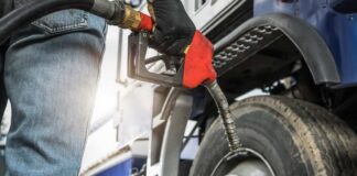 Person fueling a large truck with a gas pump