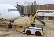 Airplane parked at the gate with boarding bridge and ground equipment
