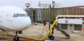 Airplane parked at the gate with boarding bridge and ground equipment
