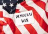 A notepad with the words 'DEMOCRAT WIN' placed on an American flag