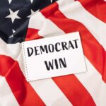 A notepad with the words 'DEMOCRAT WIN' placed on an American flag