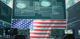 A high-tech workspace featuring multiple computer monitors displaying data and an American flag in the background