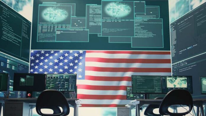 A high-tech workspace featuring multiple computer monitors displaying data and an American flag in the background