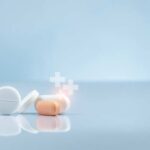 Assorted pills on a reflective surface against a light background