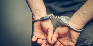 Person in handcuffs, hands behind their back.